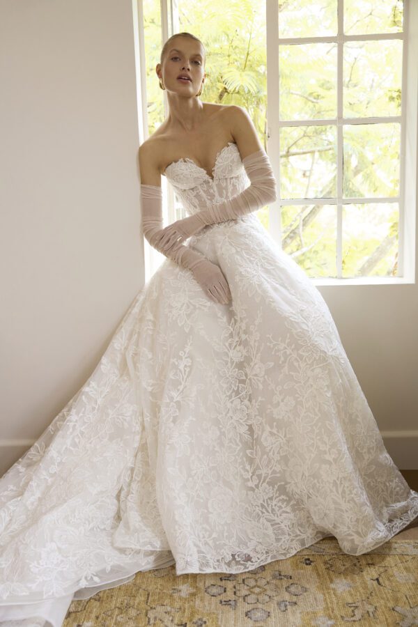 La Premiere Blossom Wedding Dress - A - Line style dress with sweetheart neckline, hand-placed floral appliqués, exposed boning bodice and long sleeves.