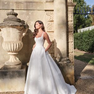 Suzanne Neville Panche Wedding Dress - Couture Modern Romantic Bridal Gown with Natural Waist, V-Neck, Plunging Neckline, Spaghetti Straps, Corset, Floral Details in Jacquard Printed Fabric.